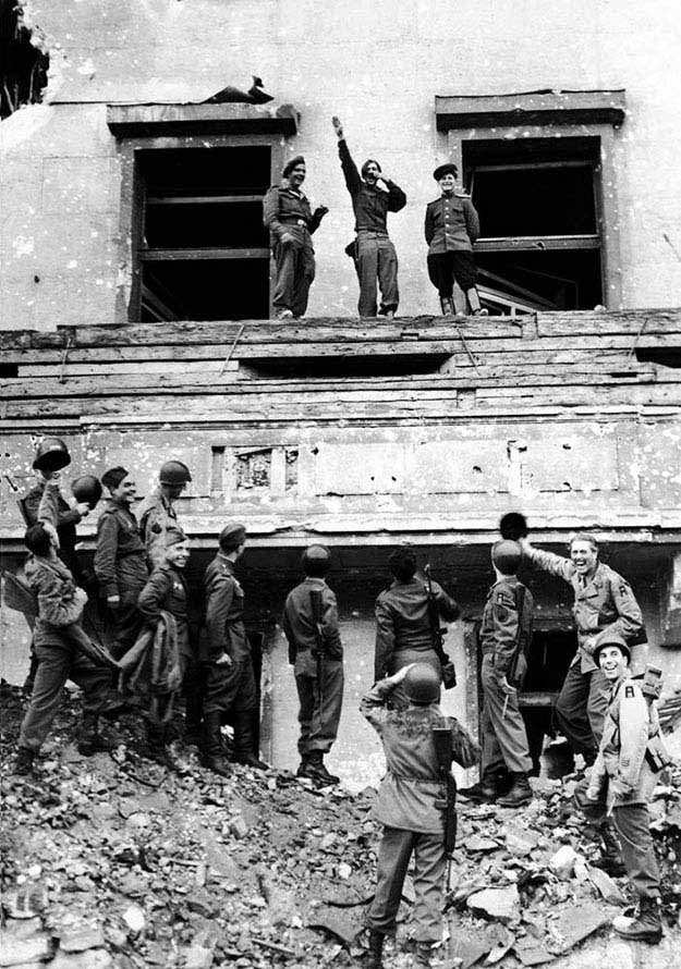 Allied soldiers mock Hitler atop his balcony at the Reich Chancellery, by Fred Ramage, 1945
