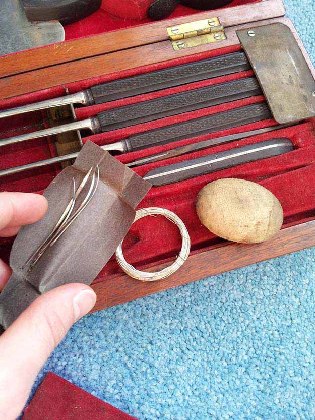 Sewing needles and metal wire for thread, along with a small object used to hammer the needles through