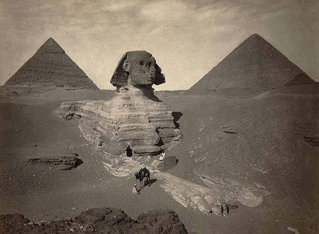 A late nineteenth century photo of the partially excavated Great Sphinx of Giza, with the Pyramid of Khafre (left) and the Great Pyramid of Giza (right) behind it