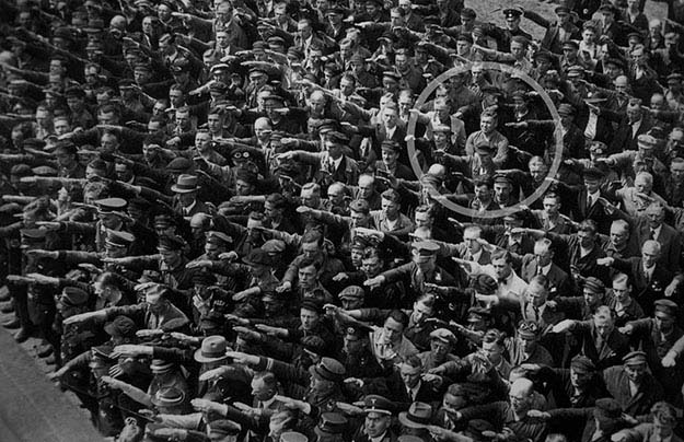 A lone man refusing to do the “Sieg Heil” salute at the launching of the Horst Wessell in Nazi Germany, 1936