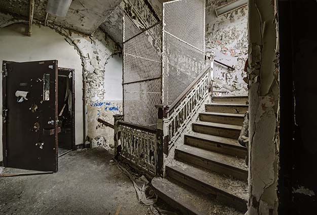 Stair well of abandoned asylum NY complete with suicide cages