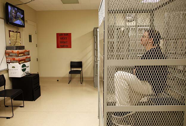 Cory Adams watches a movie from a cage in the medical facility at San Quentin state prison