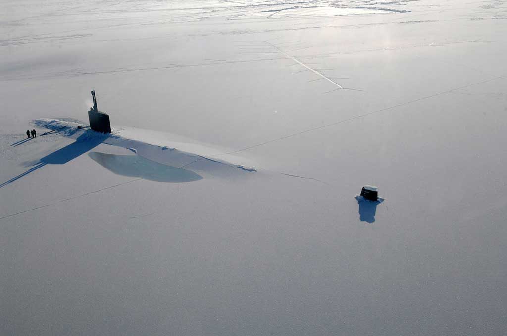 a submarine surfaces through arctic ice