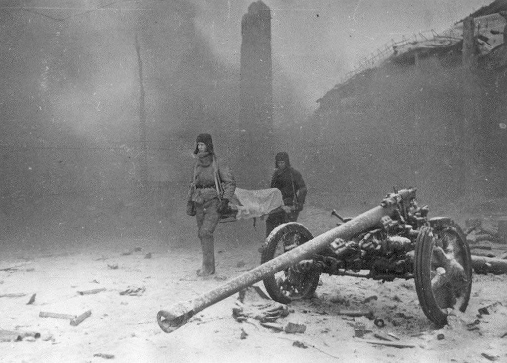 Two Soviet soldiers evacuate a wounded comrade from a factory building
